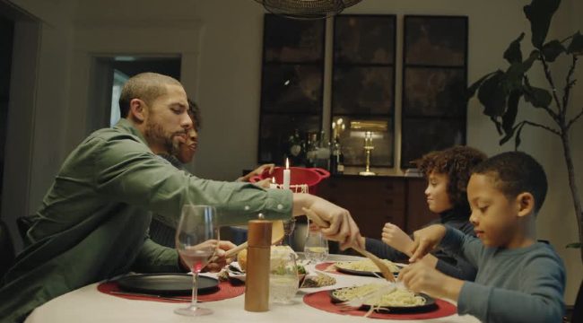A father serving dinner to his kids at the family table