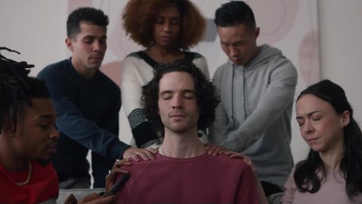 A group praying over a young man